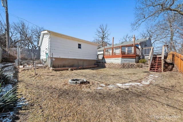 back of property with stairs, an outdoor fire pit, fence, and a deck