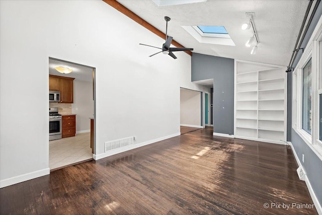 unfurnished living room with a skylight, visible vents, a textured ceiling, wood finished floors, and baseboards