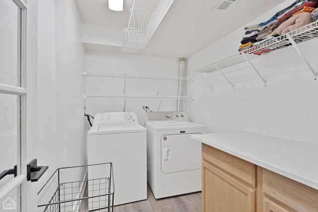 laundry room featuring light hardwood / wood-style flooring and washing machine and clothes dryer