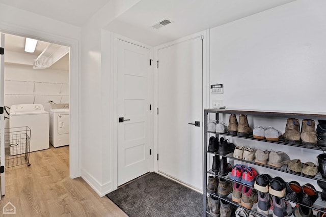 entryway with washer and clothes dryer and light hardwood / wood-style flooring