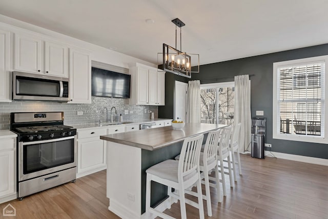 kitchen featuring a kitchen island, white cabinetry, and appliances with stainless steel finishes