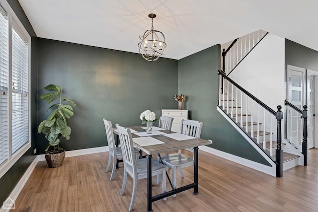 dining space with light hardwood / wood-style floors and a chandelier