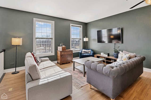 living room featuring light hardwood / wood-style floors and ceiling fan