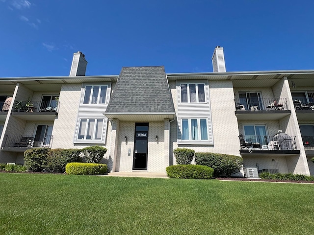 view of front of home featuring central AC unit and a front lawn