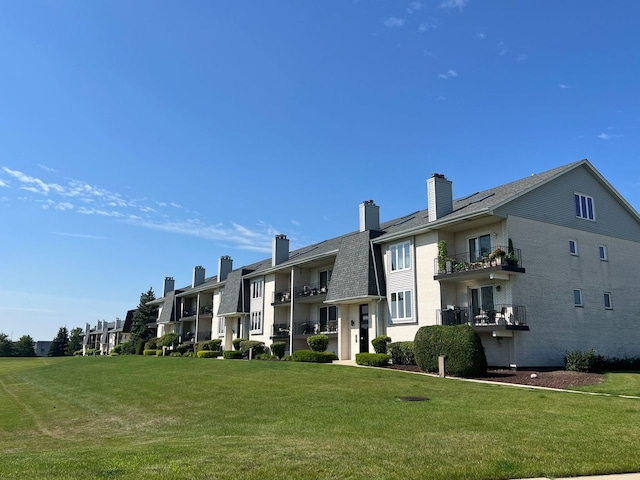 rear view of property featuring a lawn