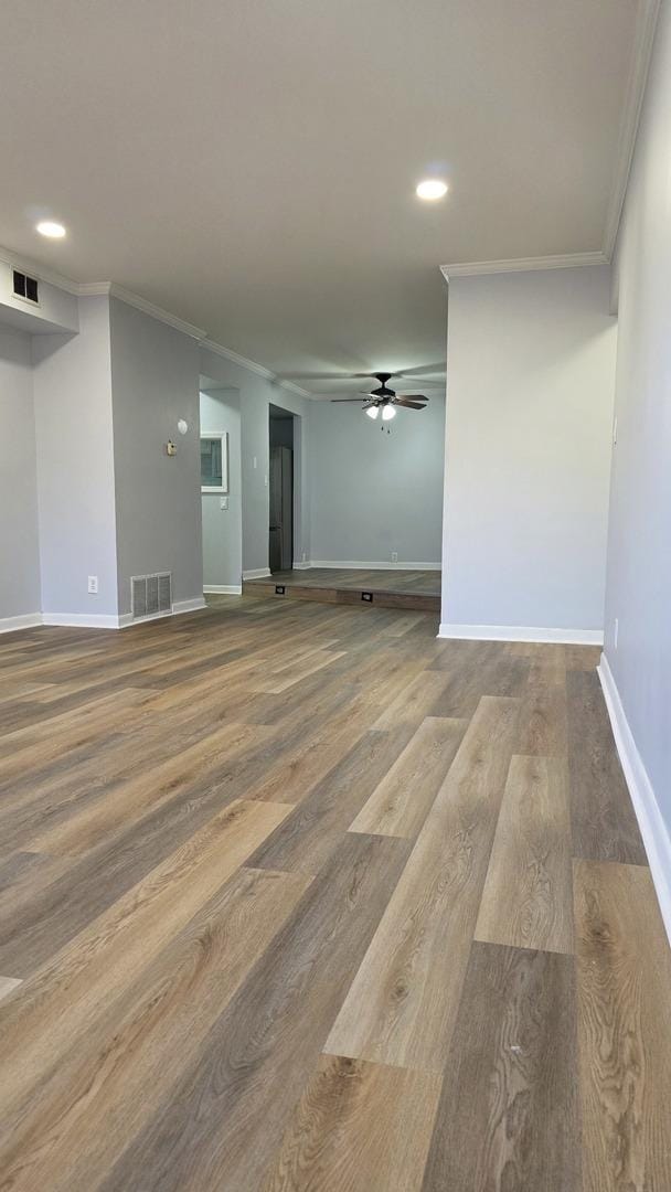 unfurnished room featuring hardwood / wood-style flooring, ornamental molding, and ceiling fan