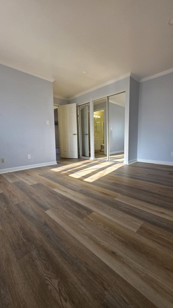 unfurnished room featuring ornamental molding and dark hardwood / wood-style flooring