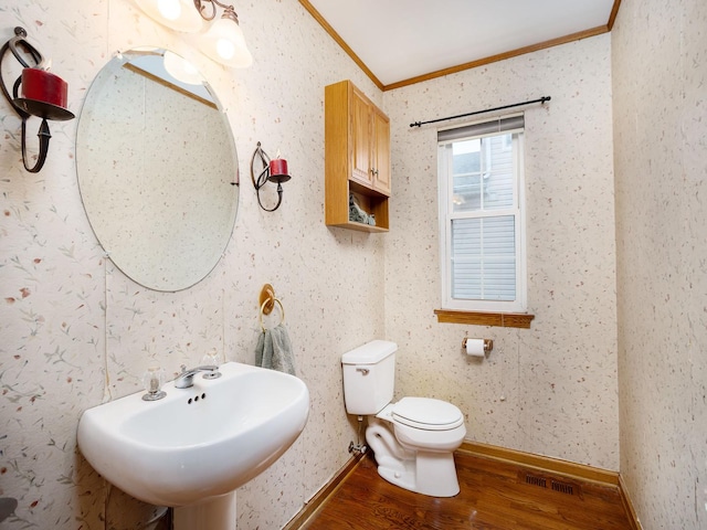 bathroom featuring crown molding, wood-type flooring, toilet, and sink