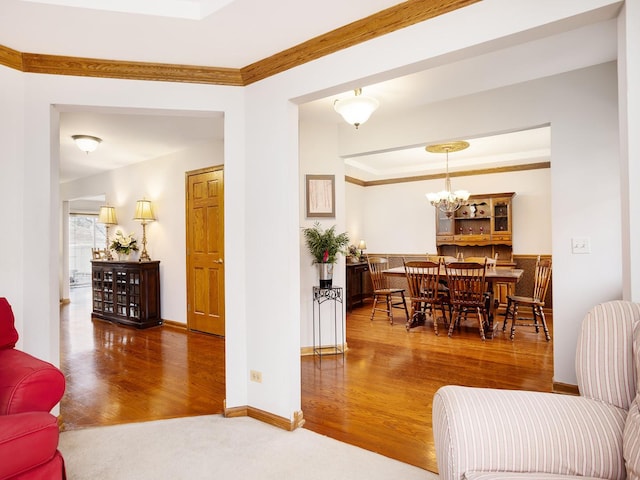 living room with crown molding, a chandelier, and hardwood / wood-style floors