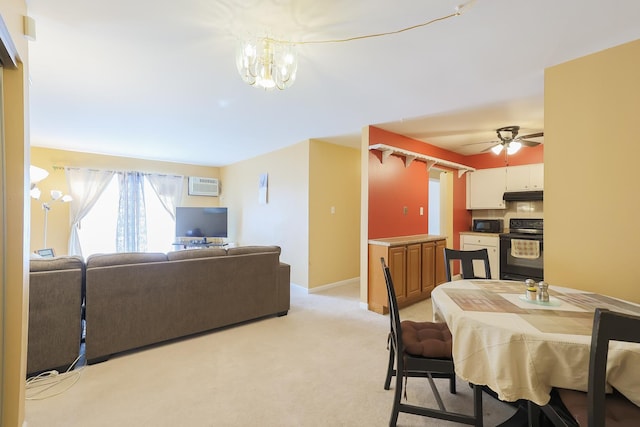 dining area featuring a wall mounted AC, ceiling fan with notable chandelier, and light carpet