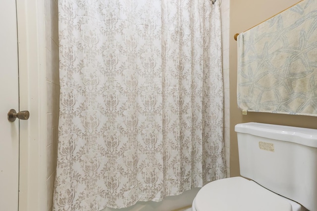 bathroom featuring toilet and a shower with shower curtain