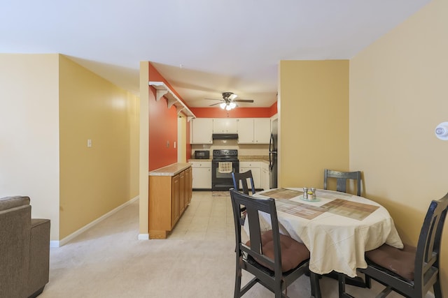 dining space featuring light colored carpet and ceiling fan