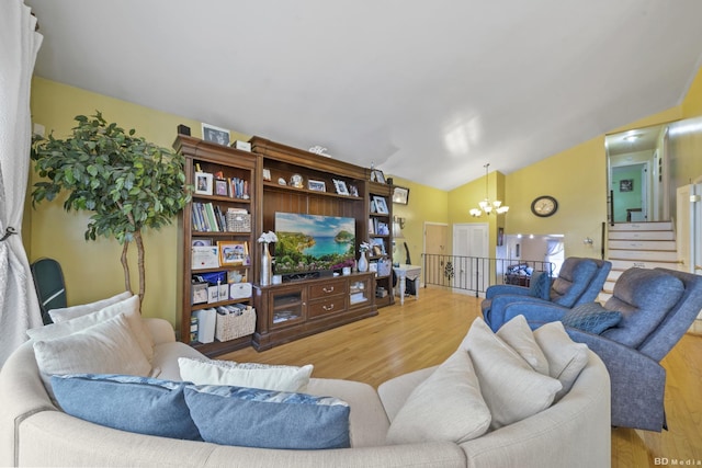 living room featuring an inviting chandelier, vaulted ceiling, and hardwood / wood-style floors