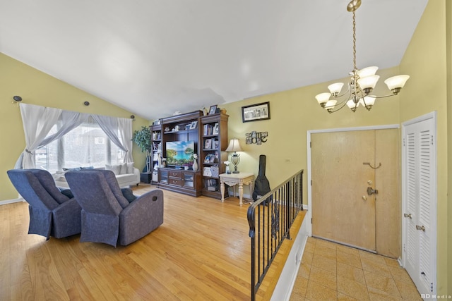 living room with vaulted ceiling, an inviting chandelier, and light wood-type flooring