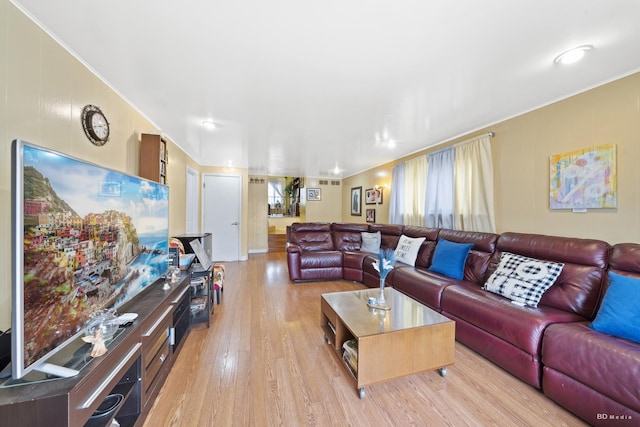 living room with crown molding and light hardwood / wood-style floors