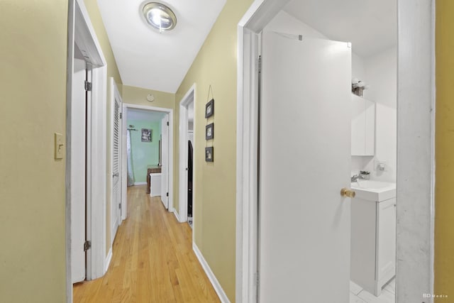 hall featuring sink and light wood-type flooring