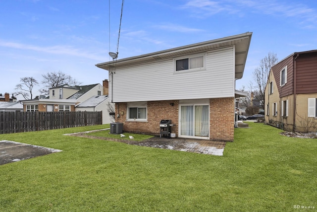 rear view of property with a yard and central AC unit