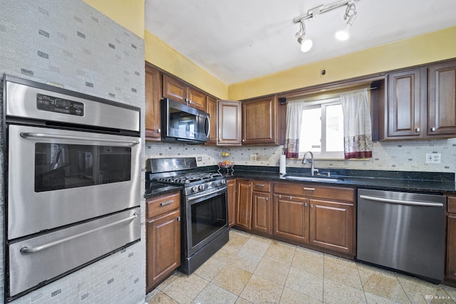 kitchen with appliances with stainless steel finishes, sink, and backsplash