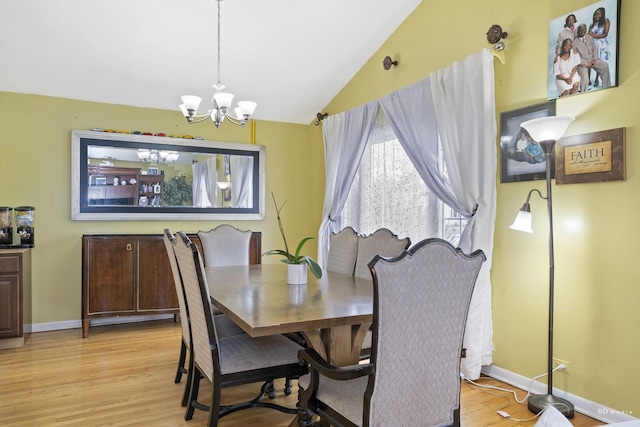 dining space with lofted ceiling, a notable chandelier, and light wood-type flooring