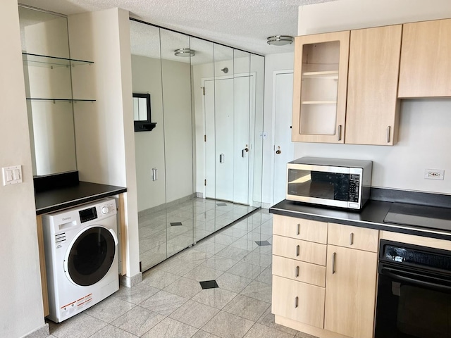 kitchen featuring washer / clothes dryer, a textured ceiling, light brown cabinetry, and black appliances