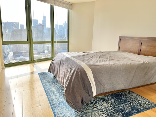 bedroom featuring wood-type flooring and floor to ceiling windows