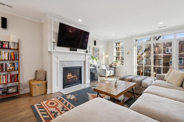 living room with hardwood / wood-style floors, a fireplace, and ornamental molding