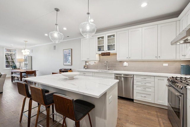 kitchen featuring white cabinetry, sink, stainless steel appliances, and a center island