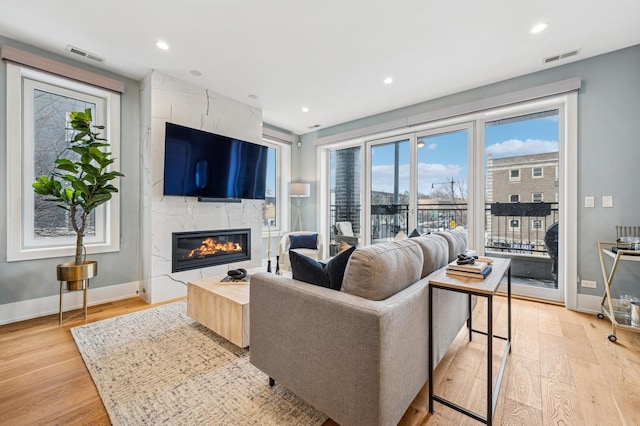 living room with a premium fireplace and light hardwood / wood-style floors