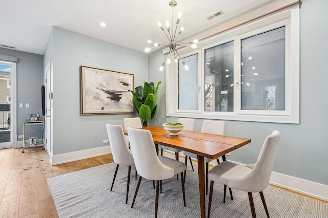 dining space with a chandelier and light hardwood / wood-style floors