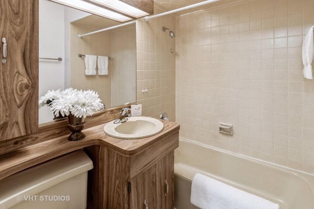 full bathroom with vanity, tiled shower / bath combo, and toilet