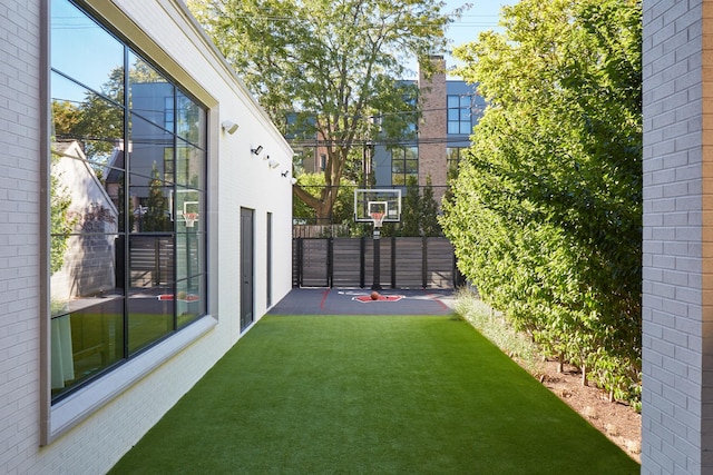 view of sport court featuring a lawn