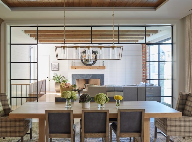 dining area with wood ceiling and a fireplace