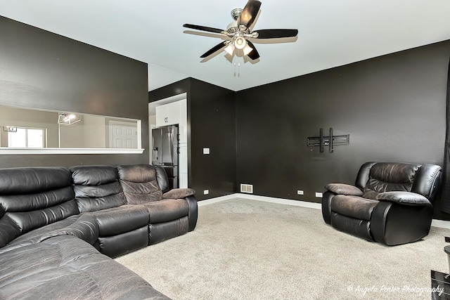 carpeted living room with ceiling fan