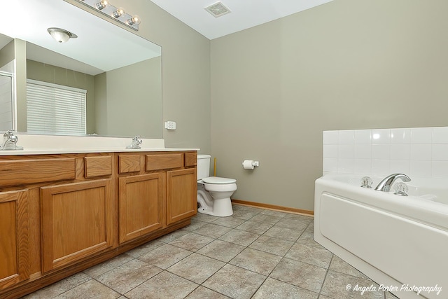 bathroom featuring vanity, a washtub, tile patterned floors, and toilet