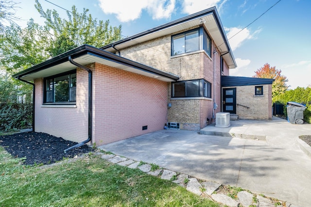 rear view of house with central AC and a patio area