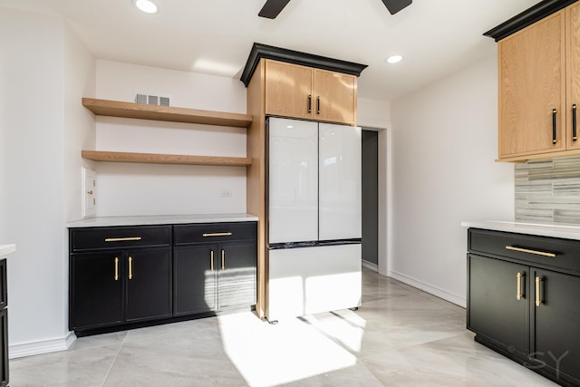 kitchen with white refrigerator, ceiling fan, light brown cabinetry, and decorative backsplash