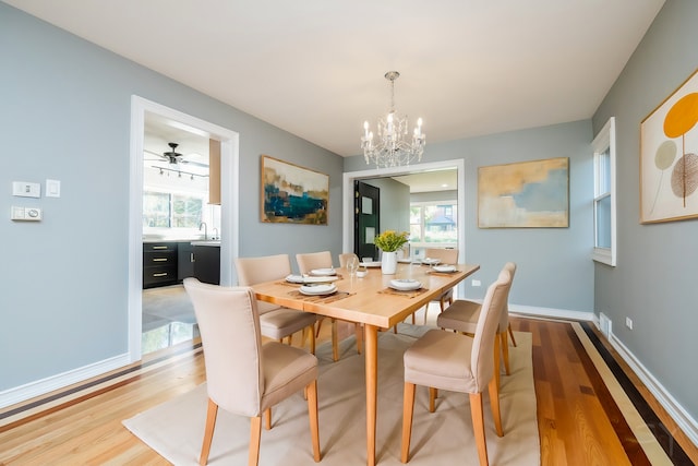 dining area with hardwood / wood-style flooring, sink, and a notable chandelier