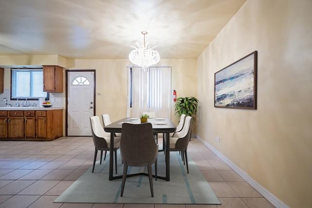 dining area featuring sink, light tile patterned floors, and an inviting chandelier