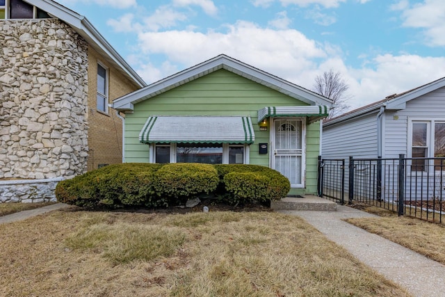 bungalow-style home with a front lawn