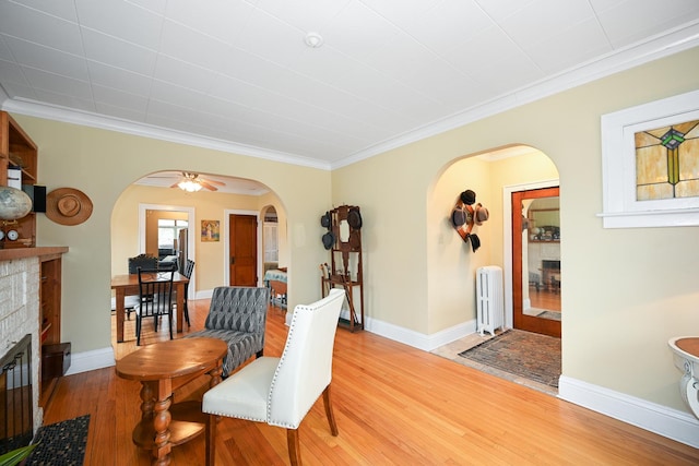 living room featuring radiator heating unit, wood-type flooring, and ornamental molding