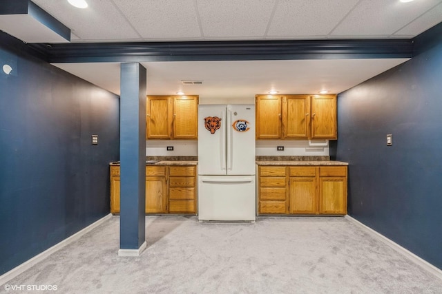 kitchen with light carpet, a drop ceiling, and white fridge