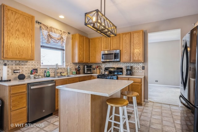 kitchen with a kitchen island, appliances with stainless steel finishes, pendant lighting, tasteful backsplash, and sink