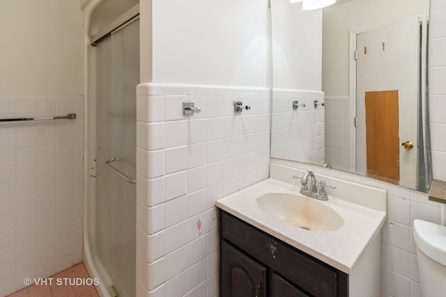 bathroom featuring tile walls, vanity, and toilet