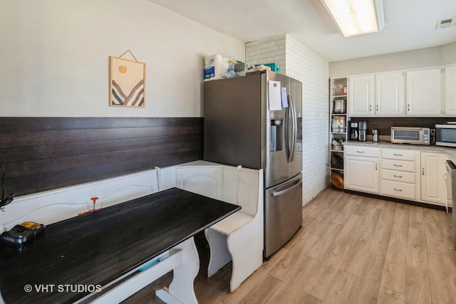 kitchen featuring appliances with stainless steel finishes, light hardwood / wood-style flooring, and white cabinets