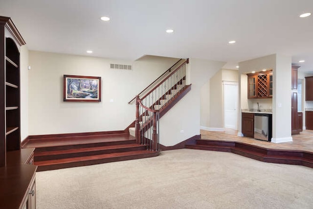 interior space with visible vents, baseboards, carpet, wet bar, and recessed lighting