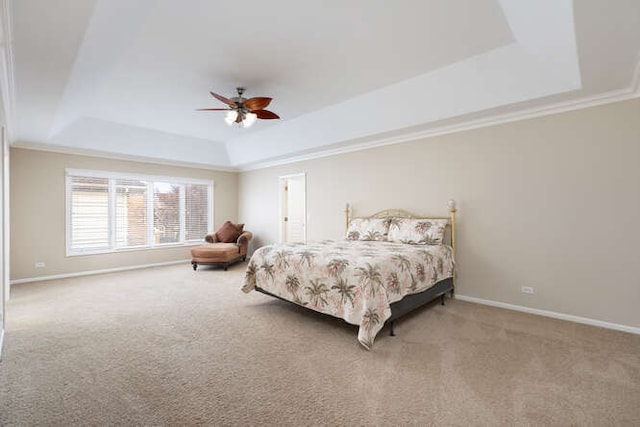 carpeted bedroom featuring baseboards, a tray ceiling, and crown molding