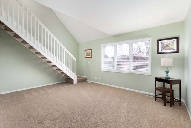 interior space with vaulted ceiling, stairway, and baseboards