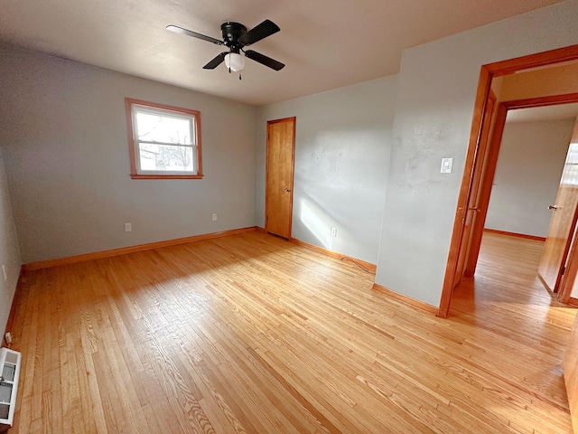 empty room with ceiling fan and light hardwood / wood-style flooring