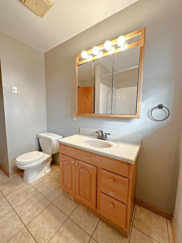 bathroom featuring tile patterned flooring, vanity, walk in shower, and toilet