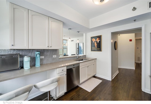 kitchen featuring dishwasher, white cabinetry, sink, hanging light fixtures, and dark wood-type flooring